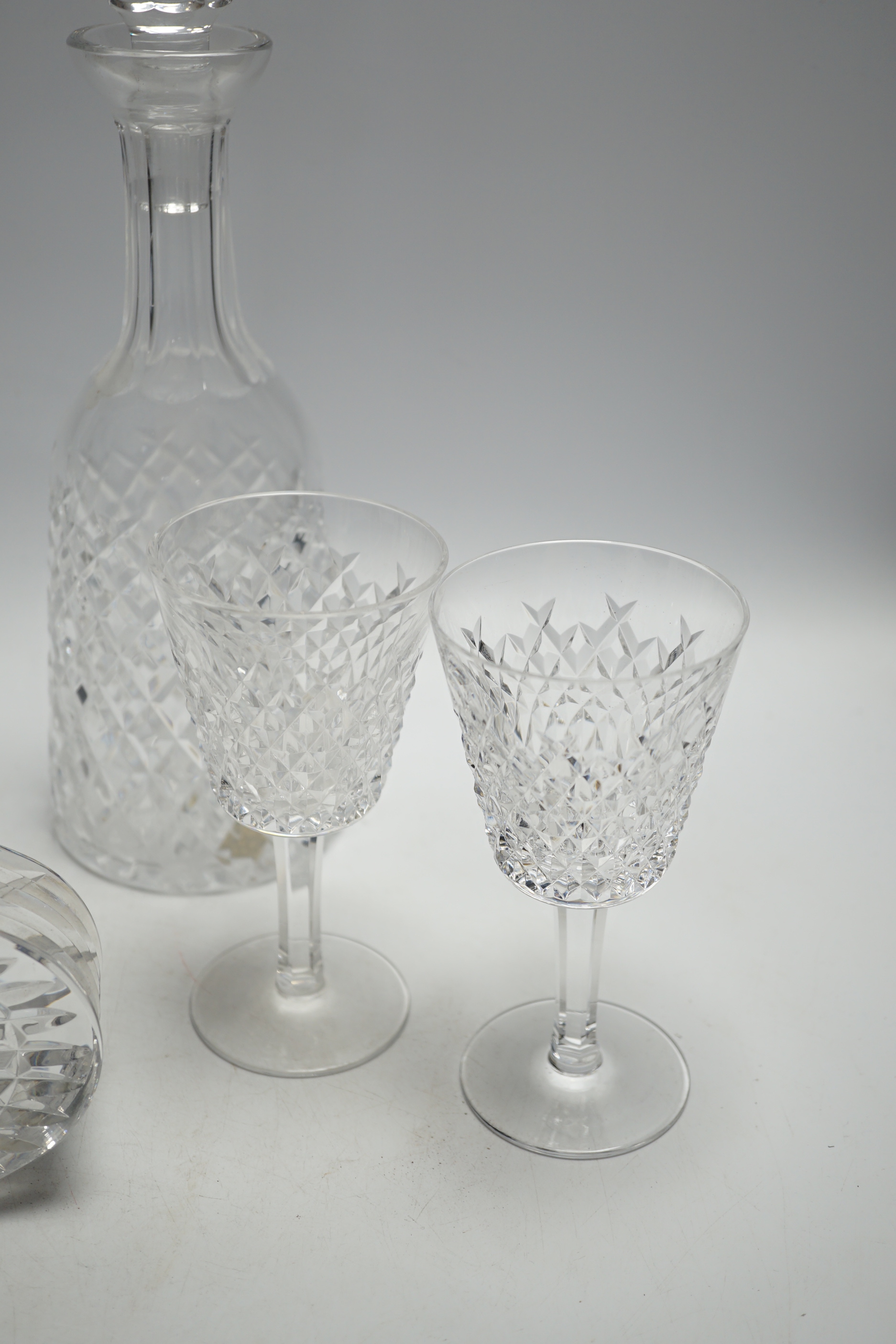 A Waterford cut glass decanter, four glasses and a timepiece